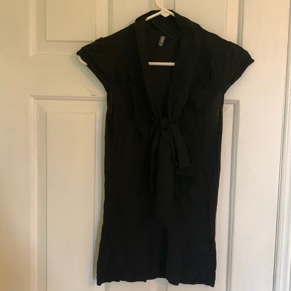 Black blouse with cuffed sleeves and ruffles around the collar. With a tie